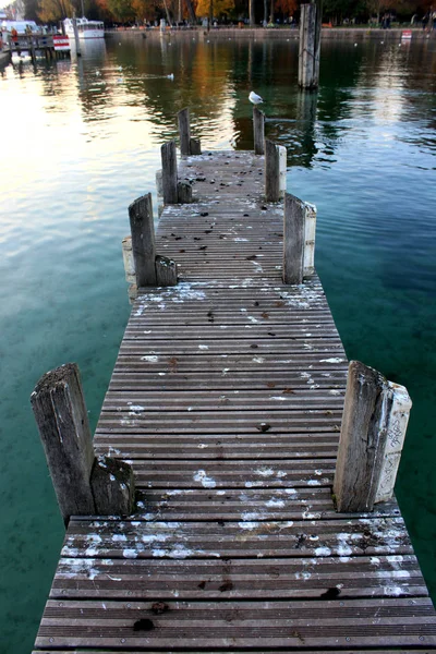 Un muelle de madera se extiende en un lago alpino cristalino en otoño, Francia — Foto de Stock