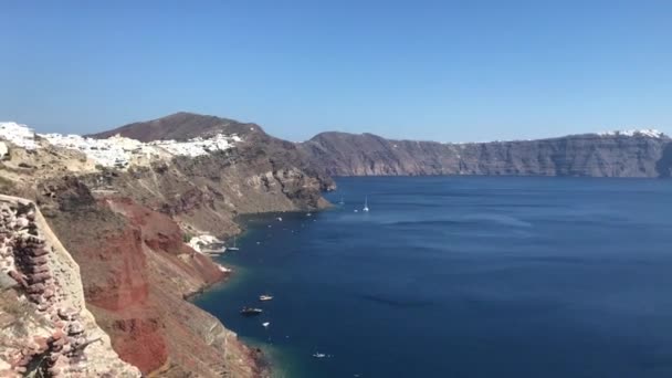 Video 4k. Rumah putih romantis yang menakjubkan di Oia, Pulau Santorini, Yunani. dengan pemandangan panorama dari seluruh tebing — Stok Video