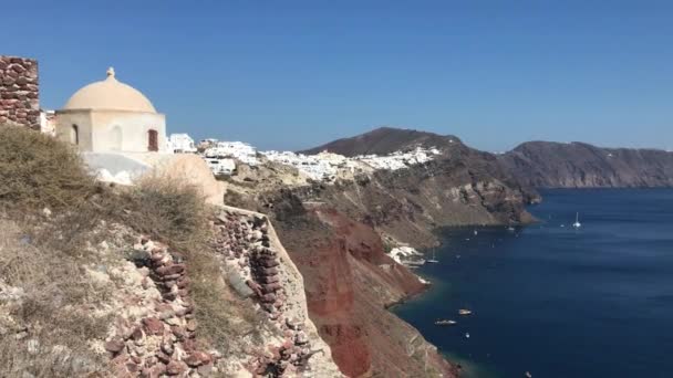 Vidéo 4k. étonnantes maisons blanches romantiques à Oia, île de Santorin, Grèce. avec vue panoramique sur toute la falaise 
