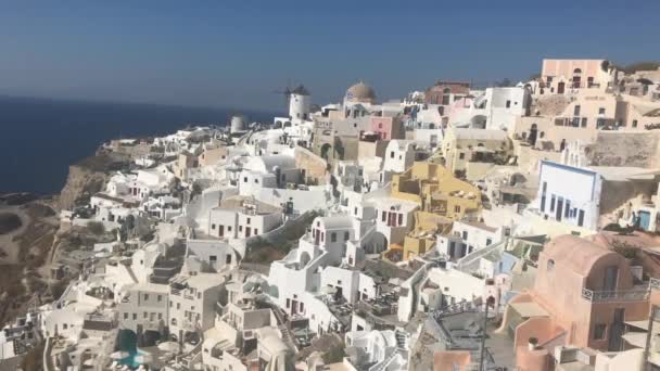 4k videa. úžasné romantické bílé domy v Oia, Santorini island, Řecko. s panoramatickým výhledem na celé skály — Stock video