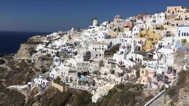 Vidéo 4k. étonnantes maisons blanches romantiques à Oia, île de Santorin, Grèce. avec vue panoramique sur toute la falaise 