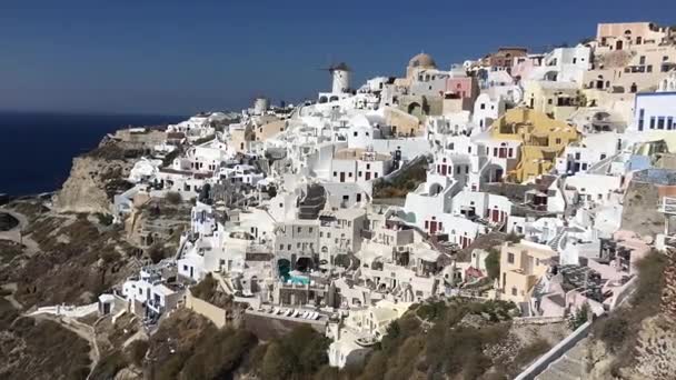 Vidéo 4k. étonnantes maisons blanches romantiques à Oia, île de Santorin, Grèce. avec vue panoramique sur toute la falaise — Video