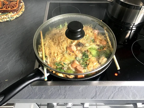 Cozinhar o macarrão frito asiático em um modernizado aquecedores de cerâmica elétrica — Fotografia de Stock