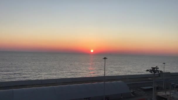 Zonsondergang op de kust van haven tijdens een zonsondergang — Stockvideo