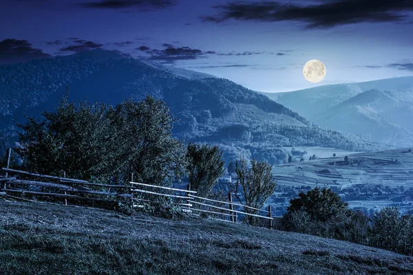 夜に山のヒルサイド草原でフェンス — ストック写真