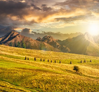 Gün batımında yüksek dağlar yakınındaki kırsal alanları