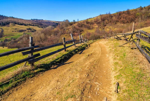 Dřevěný plot podél cesty v horách — Stock fotografie