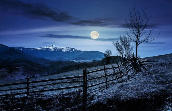 Valla de madera a lo largo del camino en las montañas por la noche — Foto de Stock