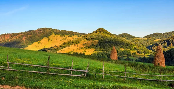 Pilas de heno en el lado de la colina — Foto de Stock