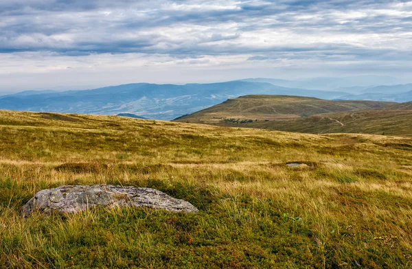Dağ sırtı üstüne çayır üzerinde büyük kayalar — Stok fotoğraf