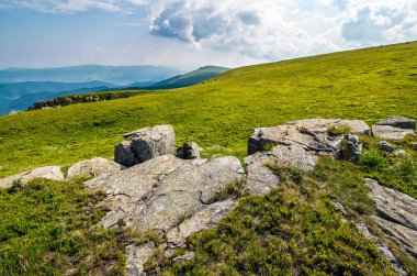 dağ sırtı üstüne çayır üzerinde büyük kayalar