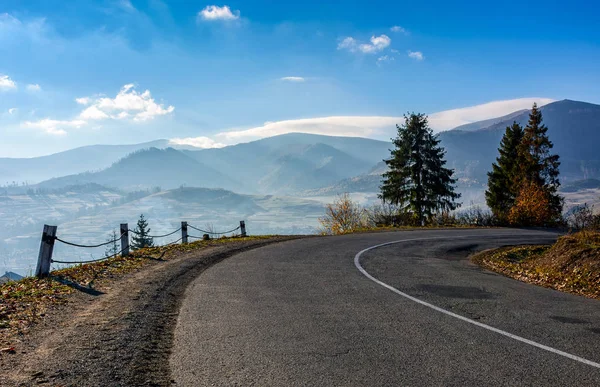 Trees on serpentine in mountains at sunrise — Stock Photo, Image