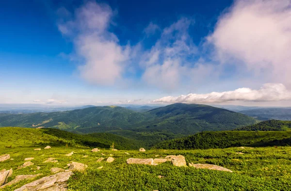 Blue cloudy sky over the mountains with rocky hillside — Stock Photo, Image