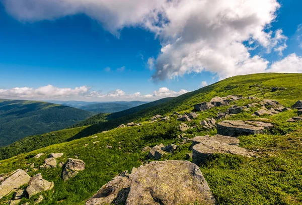 Blue cloudy sky over the mountains with rocky hillside — Stock Photo, Image