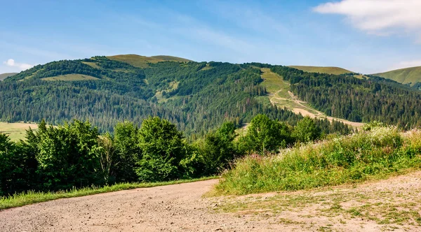 Landstraße durch Wiesen in die Berge — Stockfoto