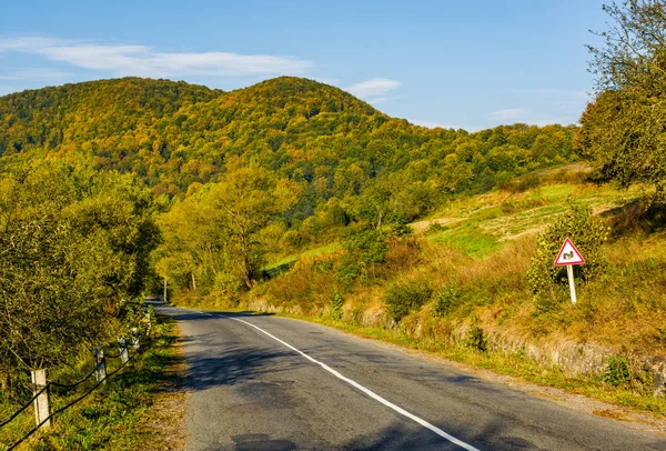 Estrada de asfalto com sinal de limitação no campo montanhoso — Fotografia de Stock