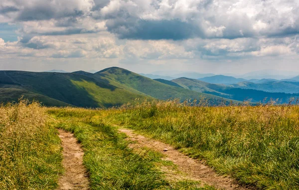 Dirt road through grassy meadow on the ridge — Stock Photo, Image