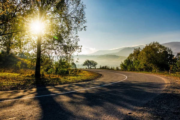 Countryside road down to the valley at sunrise — Stock Photo, Image
