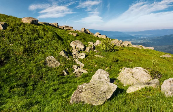Pedras enormes em uma encosta gramada em montanhas — Fotografia de Stock
