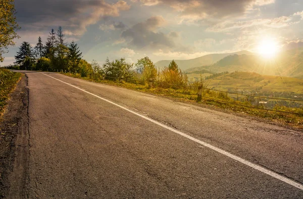 Strada di campagna attraverso le montagne al tramonto — Foto Stock