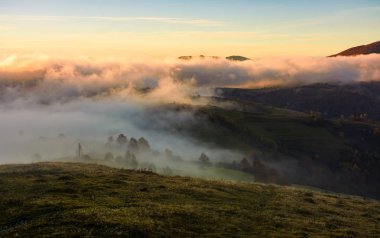 güneş doğarken tepeler üzerinde haddeleme sis