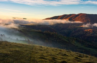 güneş doğarken tepeler üzerinde haddeleme sis