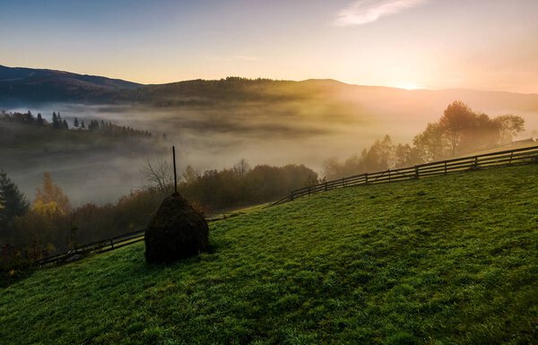 стог сена на туманное осеннее утро в горах
