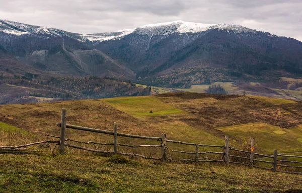 Wooden fence on hills of mountainous countryside — Stock Photo, Image