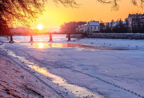 Wintersonnenaufgang am Ufer des eisbedeckten Flusses uz — Stockfoto