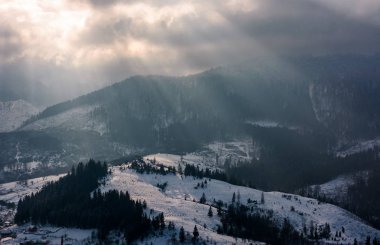 Güneş ışınları ile karlı Dağların üzerinden bulutlar 