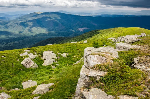 Pedregulhos em uma encosta gramada de cume de montanha — Fotografia de Stock