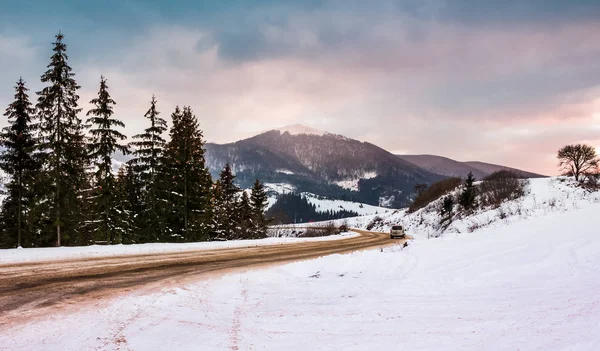 Yol dönüş yakınındaki ormanda karlı dağlar — Stok fotoğraf