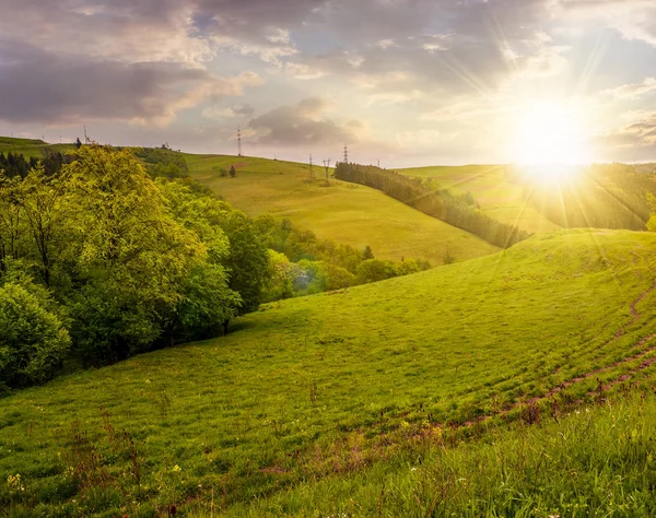 Прекрасна сільська місцевість з трав'янистими пагорбами на заході сонця — стокове фото