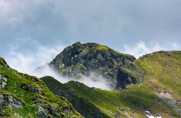 Pico de la montaña sobre el acantilado y las nubes — Foto de Stock