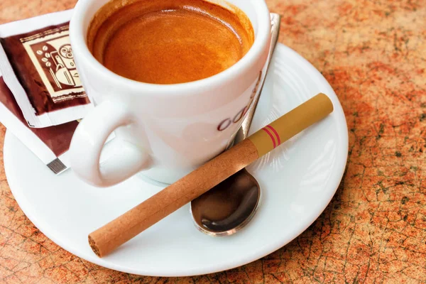 桌上放了一杯咖啡和一小支雪茄 — 图库照片
