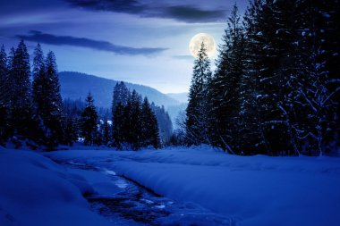 Gece donmuş ve karla kaplı dağ nehri