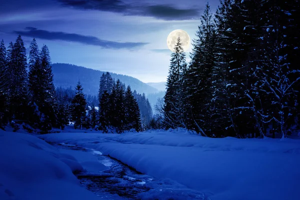 Rio de montanha congelado e coberto de neve à noite — Fotografia de Stock