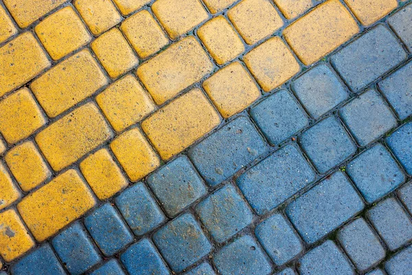 Yellow and blue cobbles of pavement texture — Stock Photo, Image