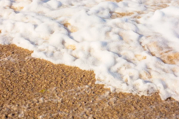 Ondas do mar espirram espuma na praia ensolarada — Fotografia de Stock