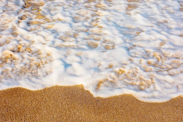 Sea waves splash foam on the sunny beach — Stock Photo, Image