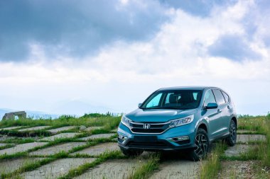 Asfaltlı çayırda mavi bir cip.