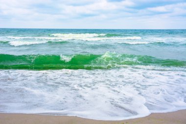 Dalgalar kumsala çarpar