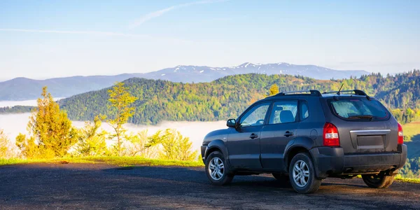 Suv Borde Una Montaña Hermosa Vista Lejano Valle Lleno Niebla — Foto de Stock