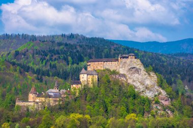 Slovakya 'nın orava kalesi. Ortaçağ kalesi dağlarda güzel bir yerde bir tepede. Bahar mevsiminde kabarık bulutlarla harika güneşli hava