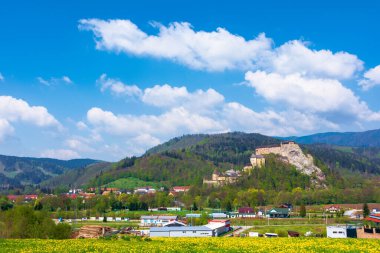 Slovakya 'nın orava kalesi. Ortaçağ kalesi dağlarda güzel bir yerde bir tepede. Bahar mevsiminde kabarık bulutlarla harika güneşli hava