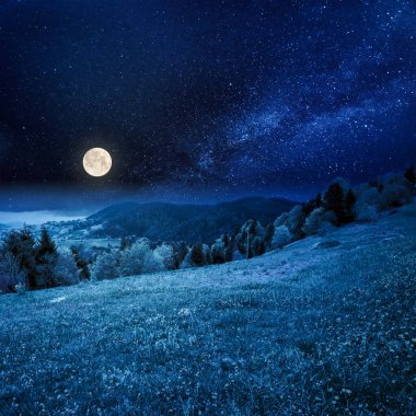 Geceleri dağlardaki güzel kırsal alan. İlkbaharda, dolunay ışığında bulutlu bir hava manzarası.