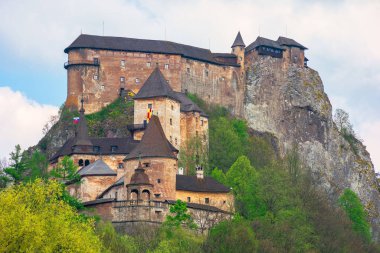 Tepedeki Ortaçağ Orava Şatosu. Nehrin üzerindeki benekli ışıkta güzel bir bahar manzarası. Slovakya 'nın popüler seyahat beldesi
