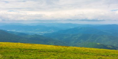 Karpatya dağlarının alp manzarası. Rüzgarlı bir yaz gününde nefes kesici manzaralar. Gökyüzündeki bulutlar. Uzakta çıkıntılar ve vadiler