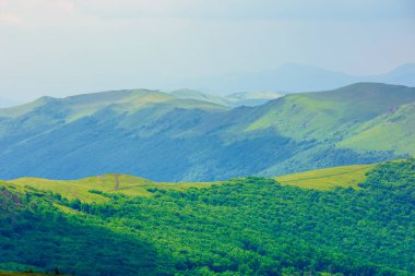 Dağ sırasına giden yol. Yazın bulutlu bir günde Karpatlar 'ın güzel dağlık çayırları. Havza sırtı bölme