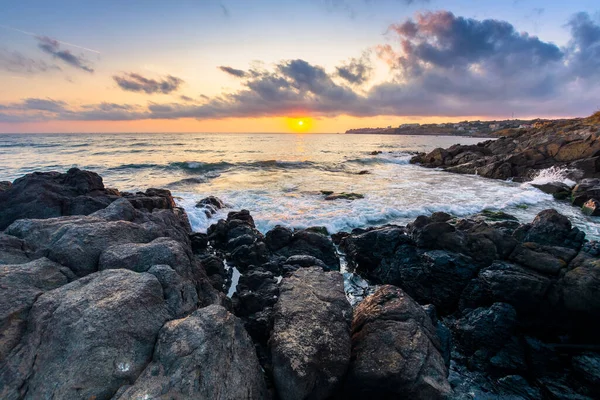 日没時に海の海岸 水の中の岩と美しい風景 太陽と地平線の上の豪華な雲 平静と調停という概念は — ストック写真